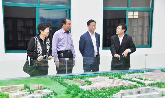 董事長劉常青向陳廣慶總干事講解學院沙盤