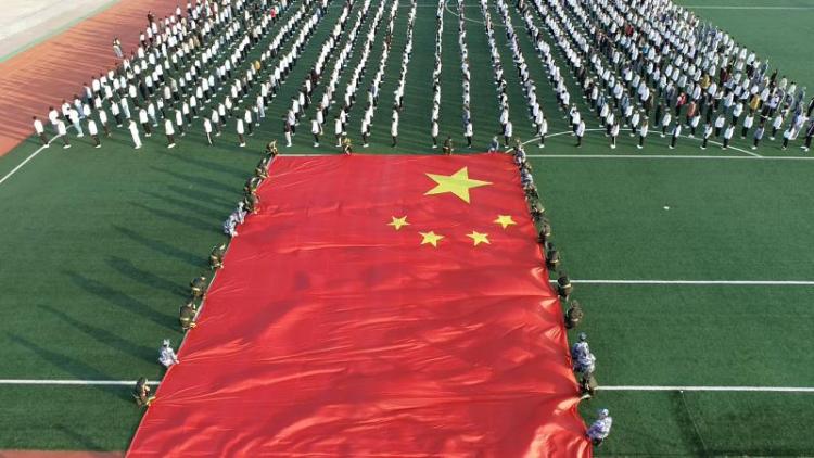 【青島日報-觀海新聞】師生齊托舉，籃球場大小的巨幅國旗舞動青島黃海學院！